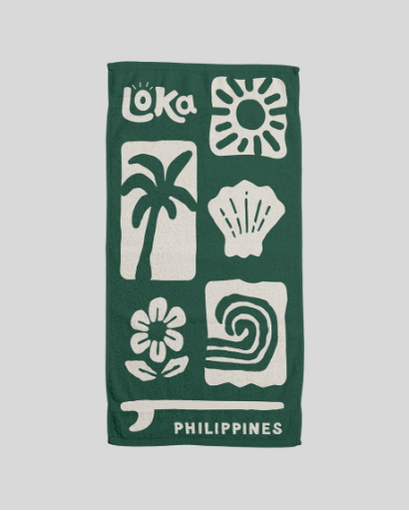 Green towel with white patterns and 'Loka' branding 