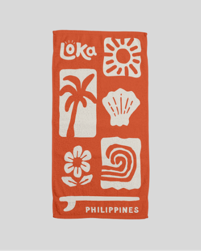 Orange towel with white patterns and 'Loka' branding 